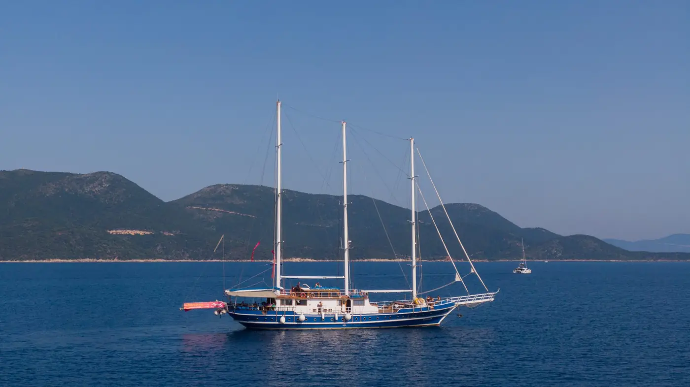 Gulet vor Anker vor einer bewaldeten Insel in der Ägäis